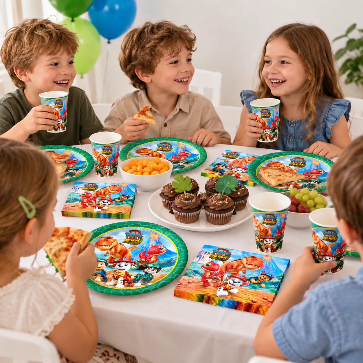 Niños merendando magdalenas con platos verdes y vasos de la Patrulla Canina Dino